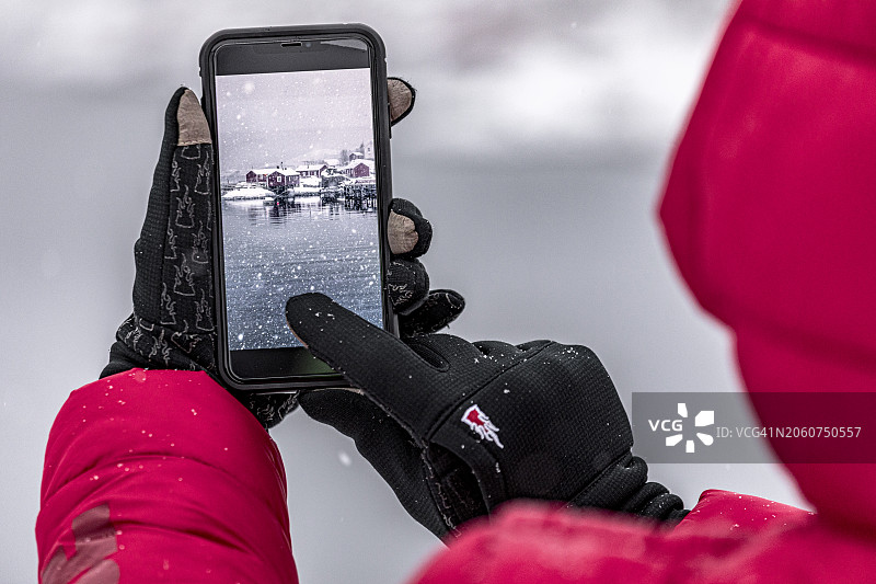 男子用智能手机拍摄峡湾的主观视角图片素材