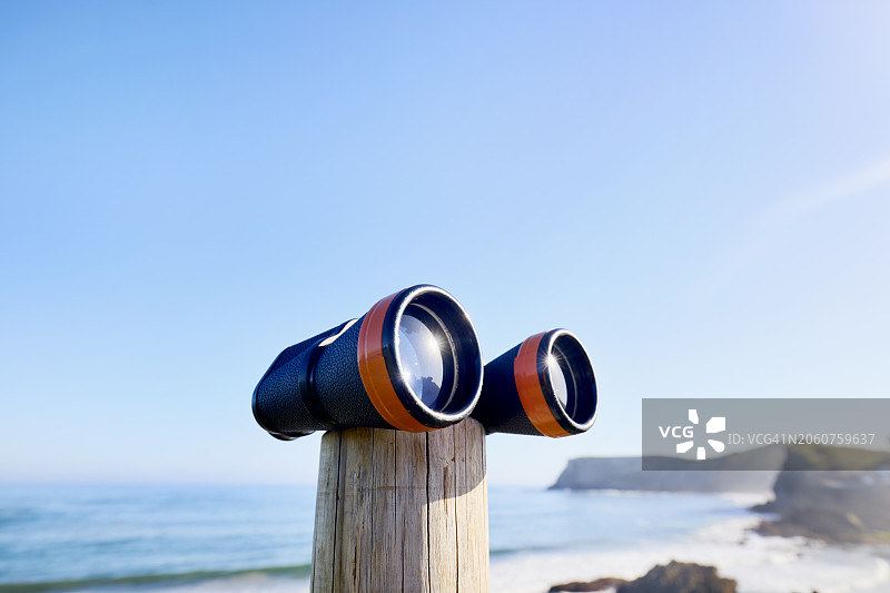 蓝天下，海边木杆上的双筒望远镜图片素材