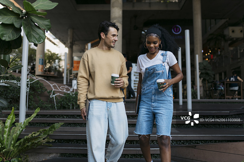 一对幸福的夫妇端着咖啡走出咖啡馆图片素材