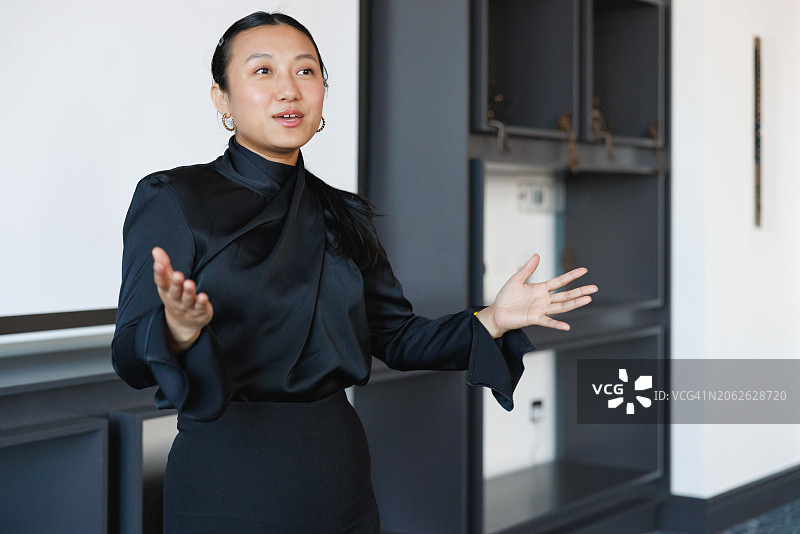 在演示会议中鼓励性发言的亚洲年轻女性图片素材