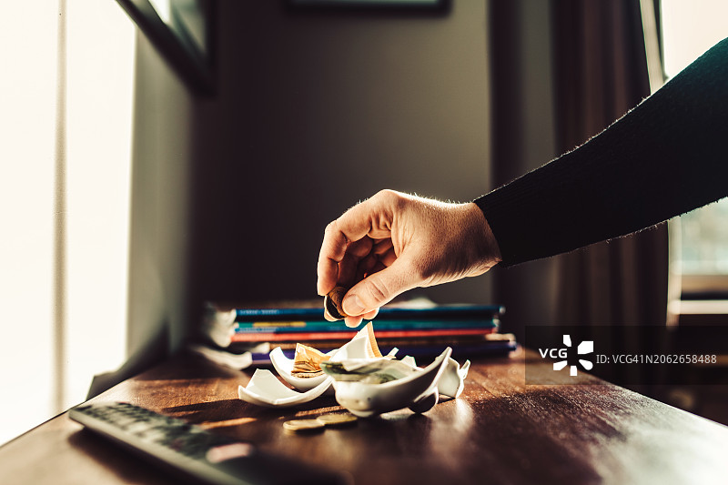 用手从破损的储蓄罐中数硬币图片素材