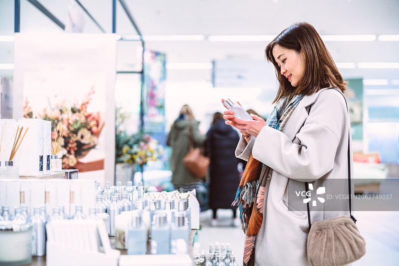 在百货商店购买家居香氛产品的漂亮亚洲女性图片素材