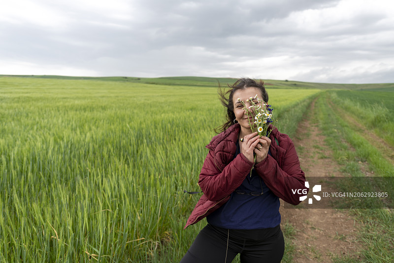 在无尽绿意前，快乐美丽女人的肖像图片素材