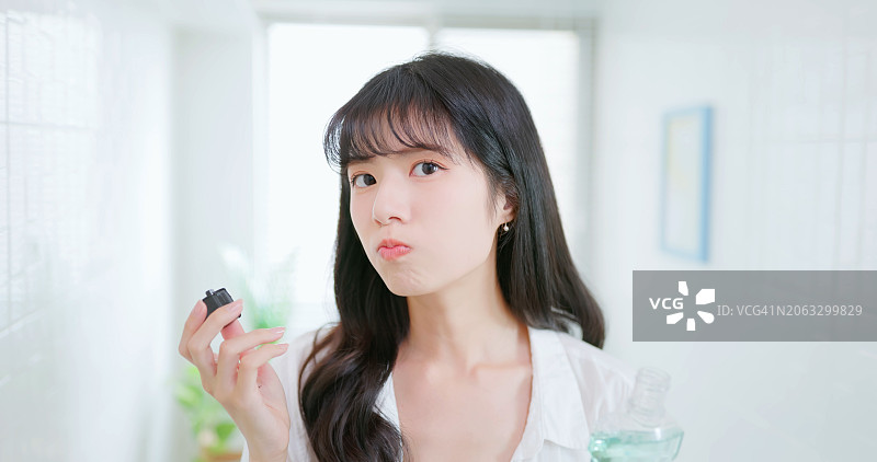 亚洲女人开心地用漱口水清洁牙齿图片素材