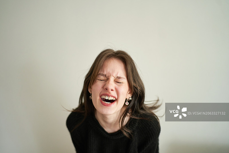 浅灰色背景上疯狂的年轻女人图片素材