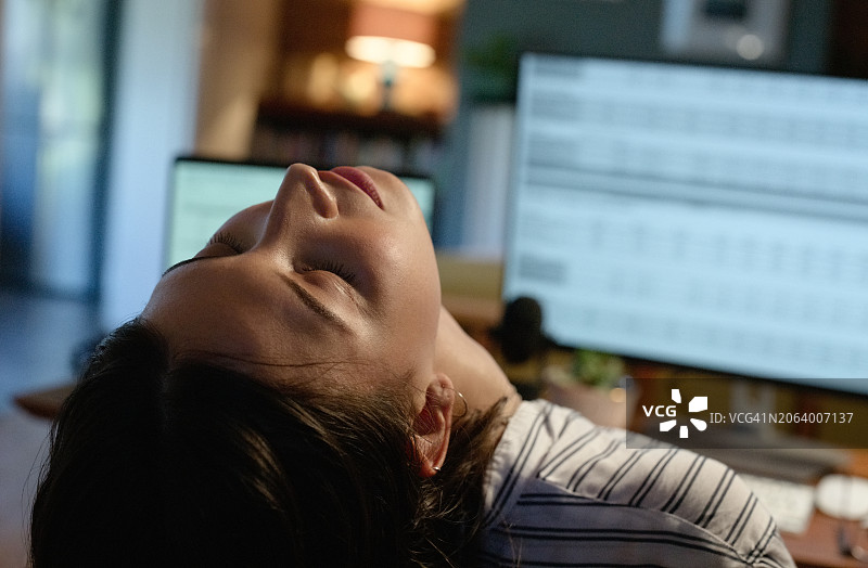 因工作而疲惫的女人：夜晚在电脑前感到压力图片素材