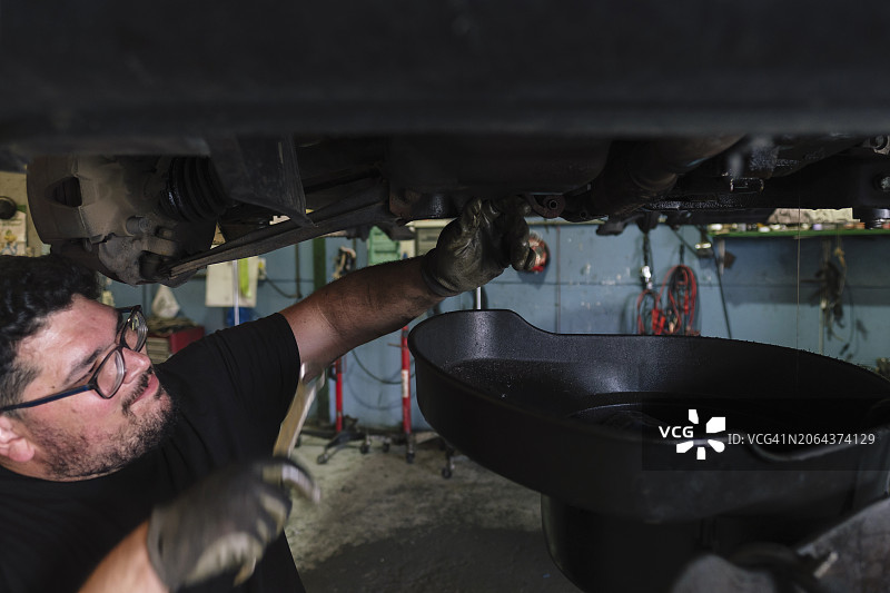 维修工在车间用扳手拆卸汽车零件图片素材