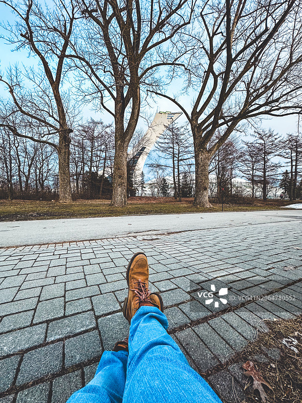 公园里面向蒙特利尔奥林匹克体育场的男人腿部POV图片素材