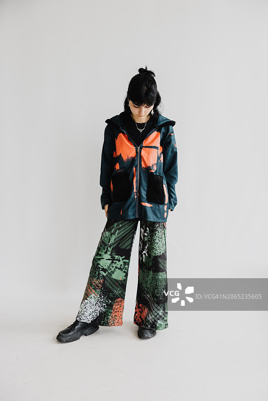 穿着喇叭裤、毛衣和靴子的年轻女性时装照图片素材