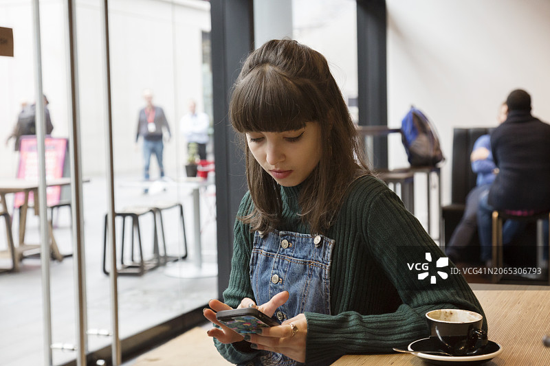 坐在咖啡馆里查看手机的女人图片素材