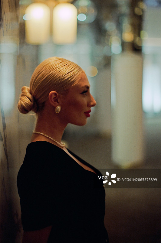 金发女人侧面肖像，站在暮光中图片素材