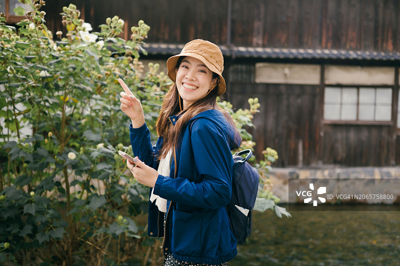 在大阪道顿堀自拍并在社交媒体上分享的亚洲Z世代独自旅行者图片素材