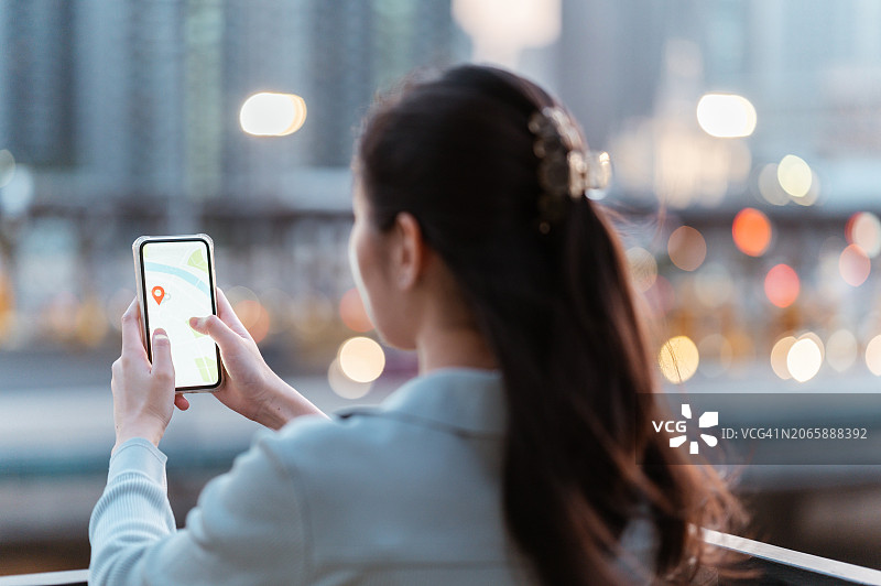 旅行者亚洲女性使用手机GPS导航搜索餐厅图片素材