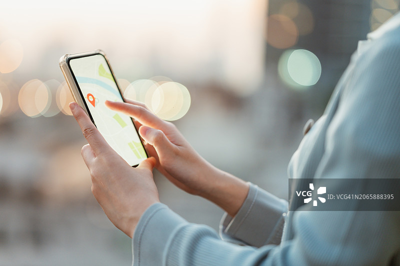 Z世代使用手机App搜索电动汽车充电站位置图片素材