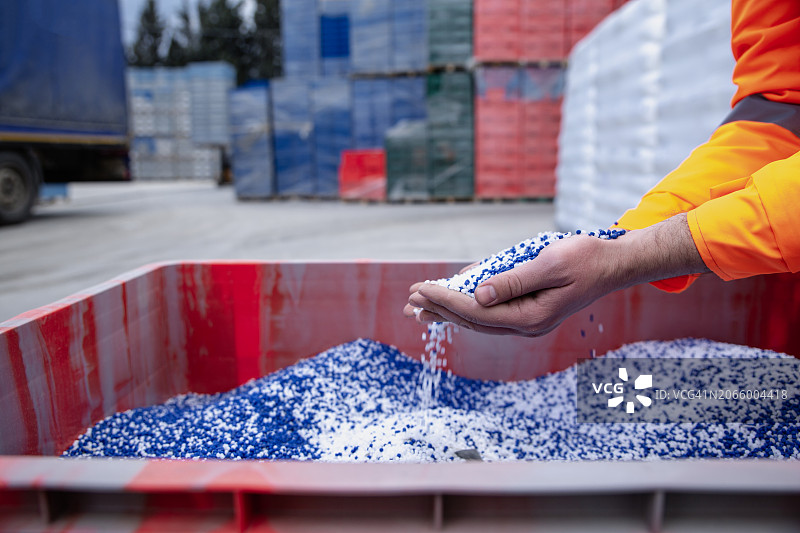 从手中倾泻而下的塑料颗粒图片素材