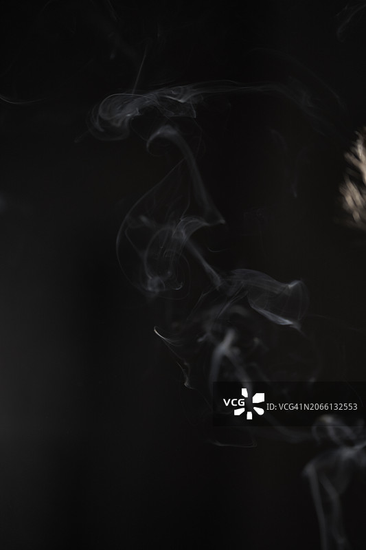 黑色背景上的雪茄烟雾，带有文案空间的版式设计图片素材