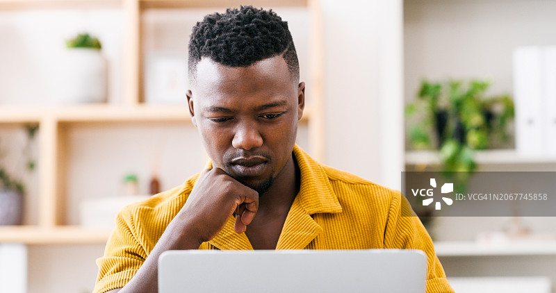办公室场景：黑人男子使用笔记本电脑进行互联网研究和数字营销分析图片素材