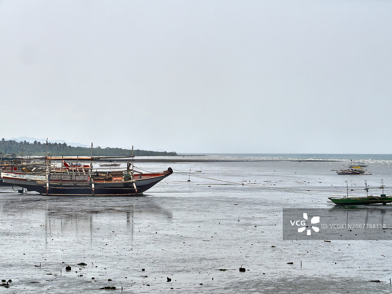 灰色天空下停在海滩上的船只横向广角镜头图片素材