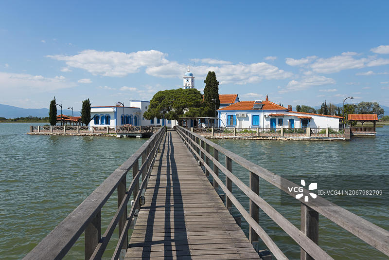 位于平静水面桥尽头的修道院建筑群,圣尼古拉斯修道院,希腊东马其顿和色雷斯克桑西州波多拉各斯维斯托尼达斯缅甸潟湖图片素材