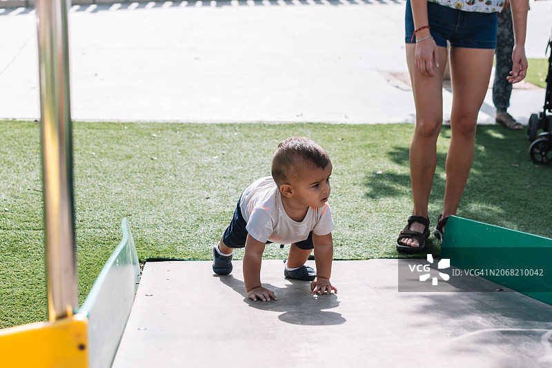 在公园坡道上爬行的孩子图片素材