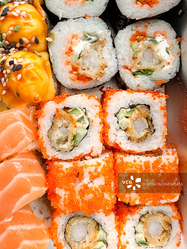 现成的寿司卷和红鱼，米饭和鳄梨。送什锦卷:费城，加利福尼亚和经典图片素材