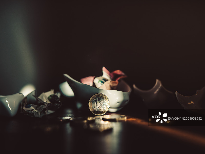 装有欧元硬币的破损储蓄罐图片素材
