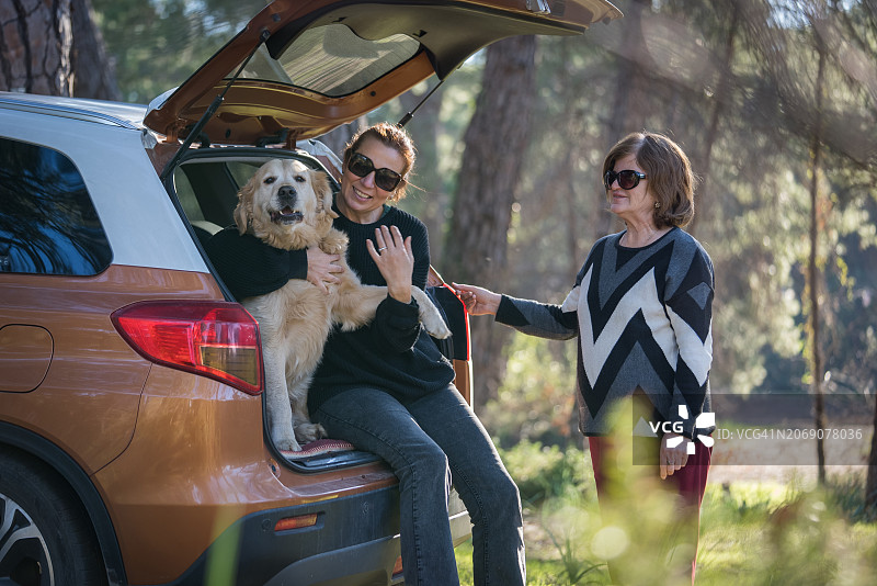 两个女人带着狗在车里休息图片素材