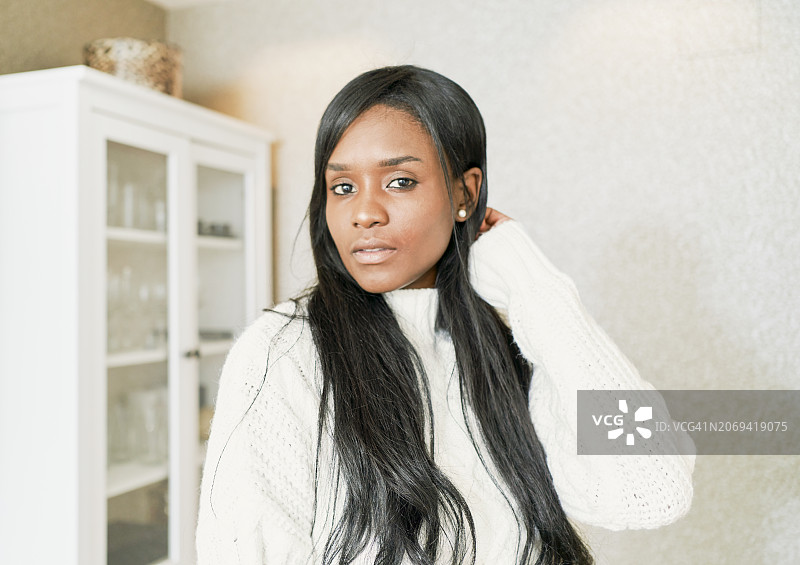 站在市中心服装店里的女企业家特写。美丽的非裔美国妇女手放在头发上看着镜头的特写图片素材