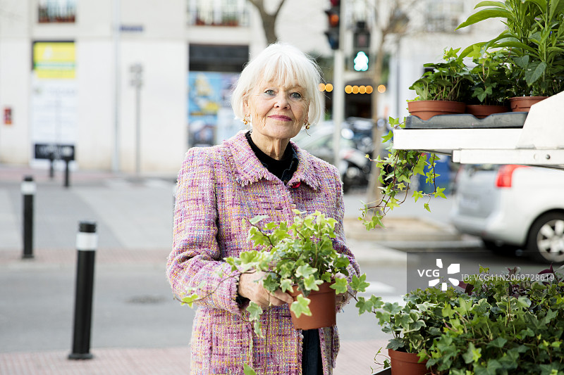 快乐的老年妇女在街边花店购买植物图片素材