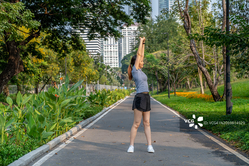 在公园慢跑后伸展身体休息的女人图片素材