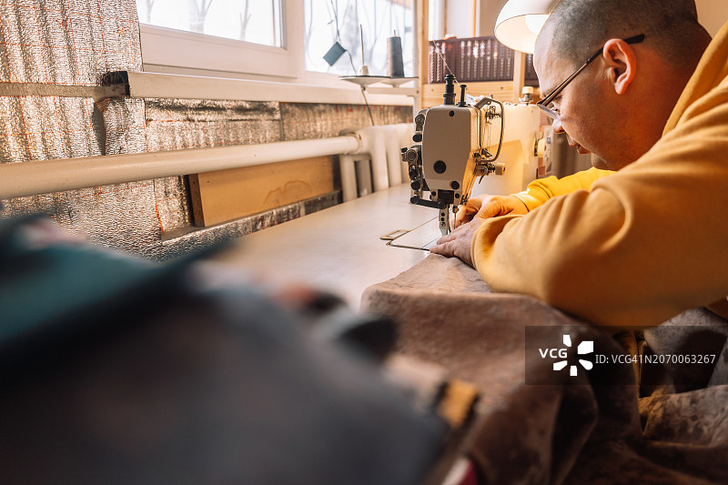 在缝纫机旁工作的家具技师图片素材