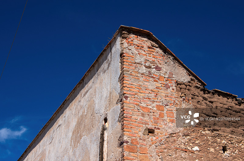 灰泥、砖和土坯殖民风格建筑一角，背景是蓝天图片素材