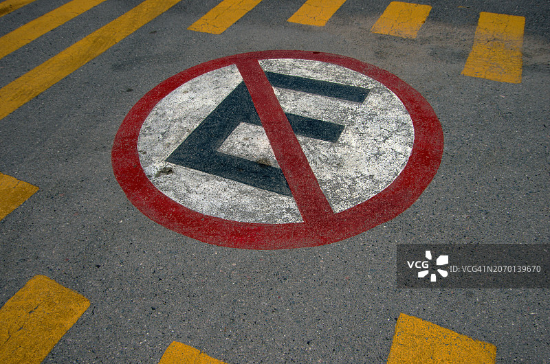 西班牙语“禁止停车”标志，绘制在条纹人行横道之间的道路上图片素材