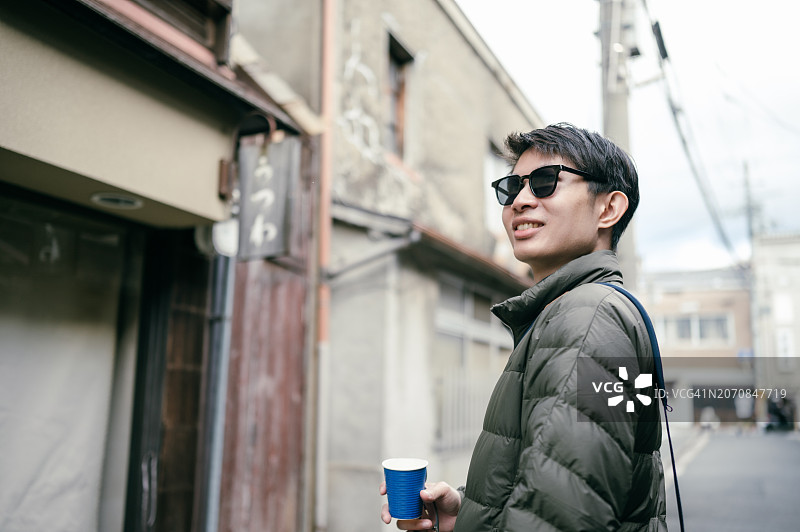 在京都街头手持咖啡杯的日本商人图片素材
