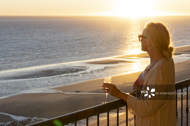 中年妇女在海边看日落图片素材