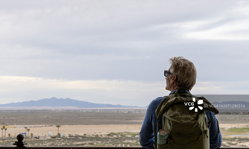 背包客在阳台上眺望沙漠图片素材