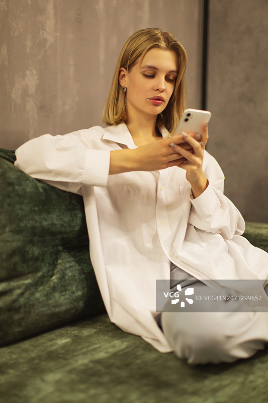 手持手机的金色头发女人图片素材