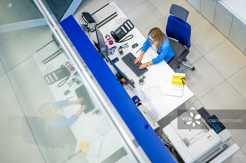 秘书在办公桌前工作的航拍照片图片素材