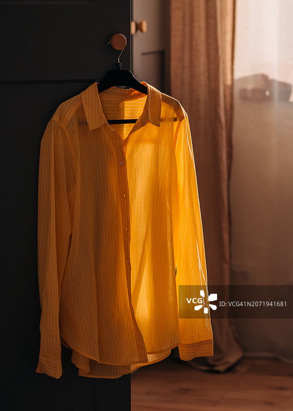 可爱年轻女人站在衣架前挑选衣服图片素材