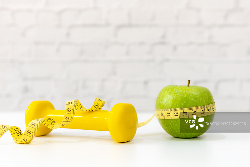 绿色苹果和卷尺特写，办公室健康饮食计划图片素材