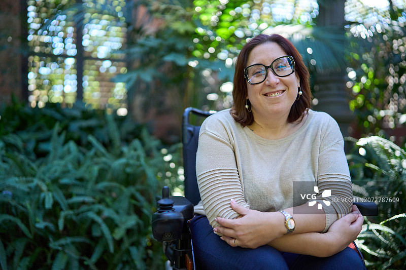 坐在轮椅上对着镜头微笑的自信女人图片素材