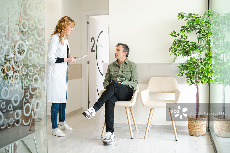 医生与坐在候诊室的患者交谈图片素材