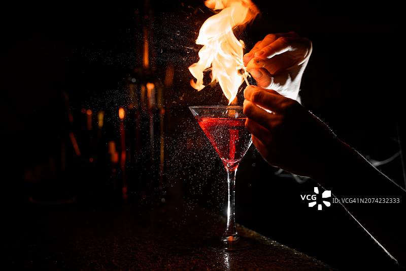 吧台上的透明鸡尾酒杯与火焰特饮图片素材