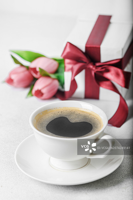 母亲节快乐，国际妇女节贺卡。母亲的咖啡，带纺织蝴蝶结的礼物和郁金香花束图片素材
