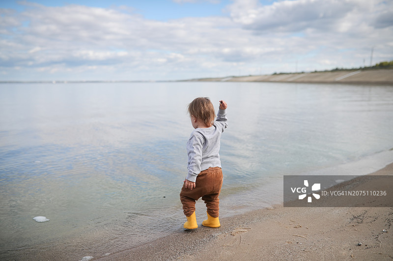 湖畔幼童掷石戏水场景图片素材