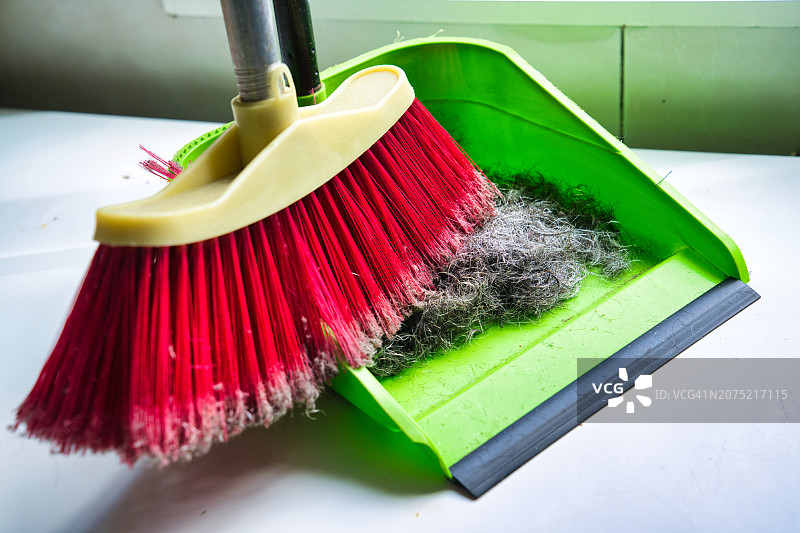 用扫帚和簸箕清扫头发图片素材