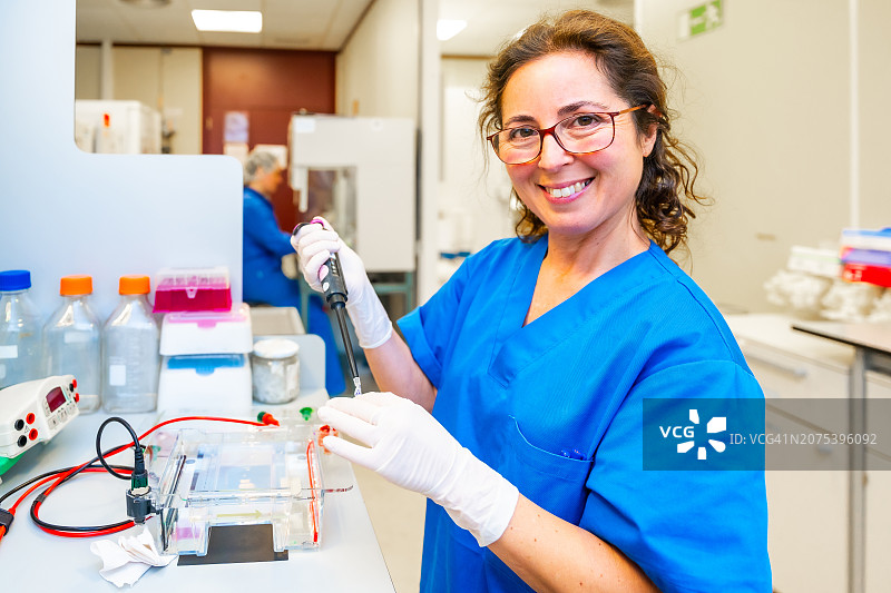 快乐的女医生在生物安全室从事癌症研究工作图片素材