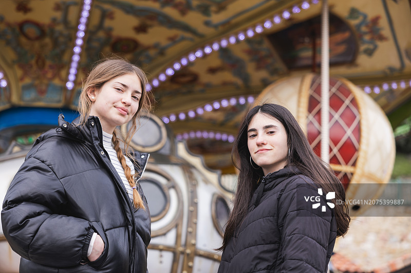 两位朋友在装饰精美的旋转木马附近享受一天图片素材