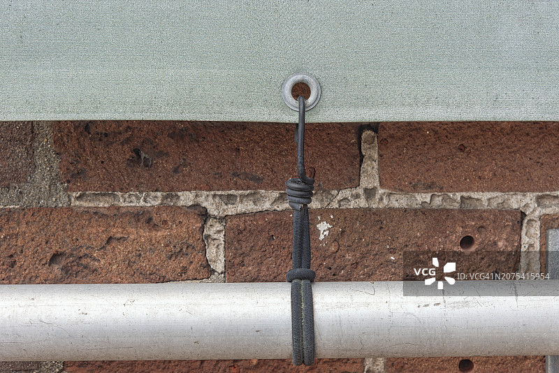 广告篷布底部与金属管的绳索弹簧连接图片素材