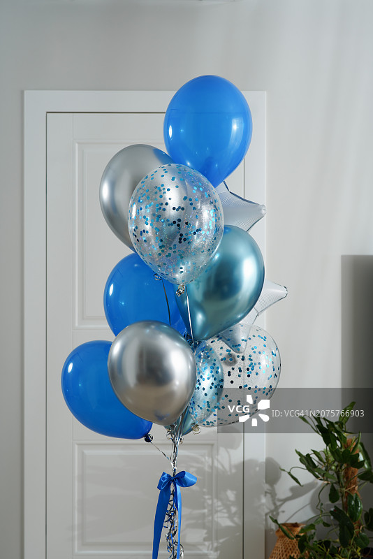 浅色背景上生日派对的蓝色银色气球图片素材